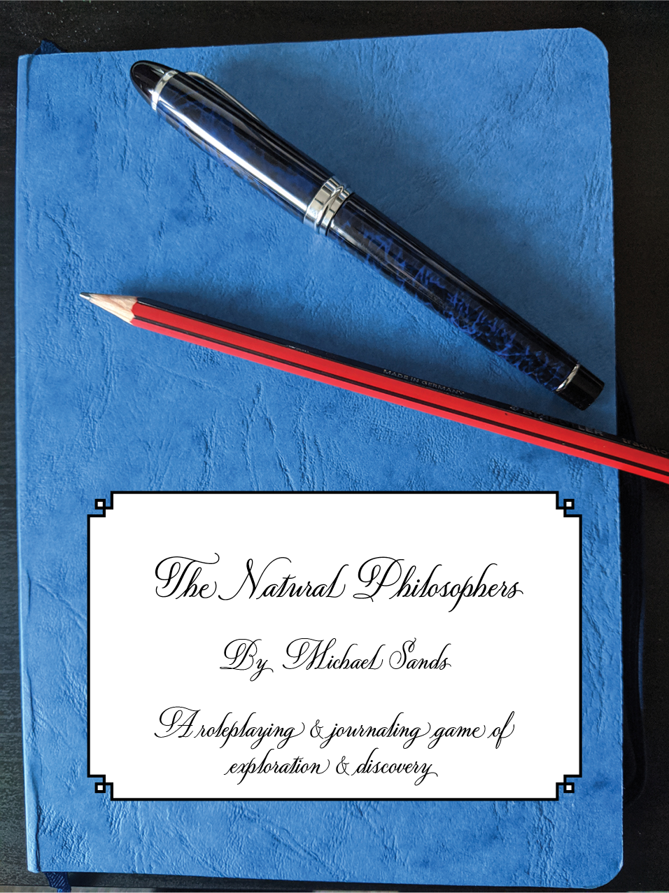 The Natural Philosophers cover, showing a notebook with pens and pencils